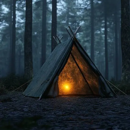 A lit tent in a foggy forest
